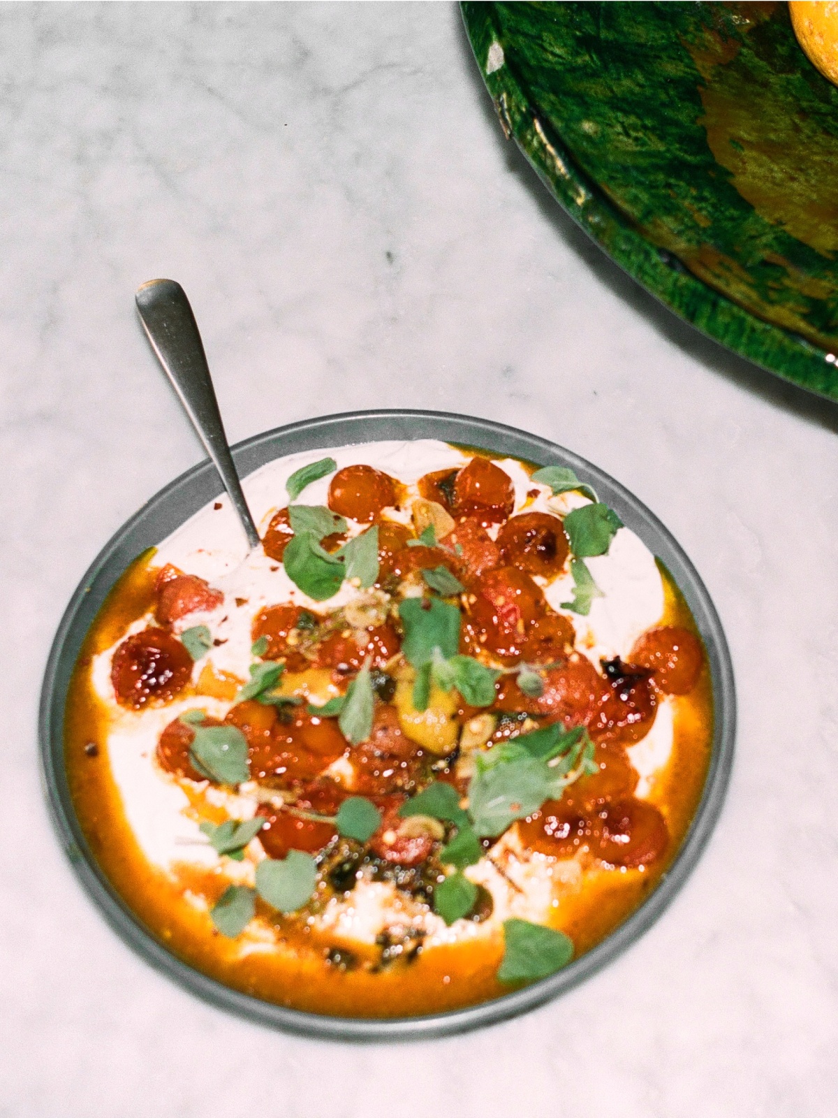 Hot cherry tomatoes on cold greek yoghurt