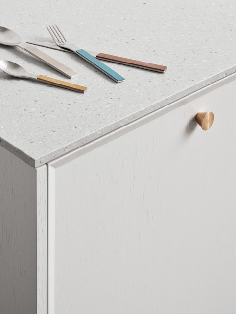 Køkkenskab med messing greb og Corian bordplade